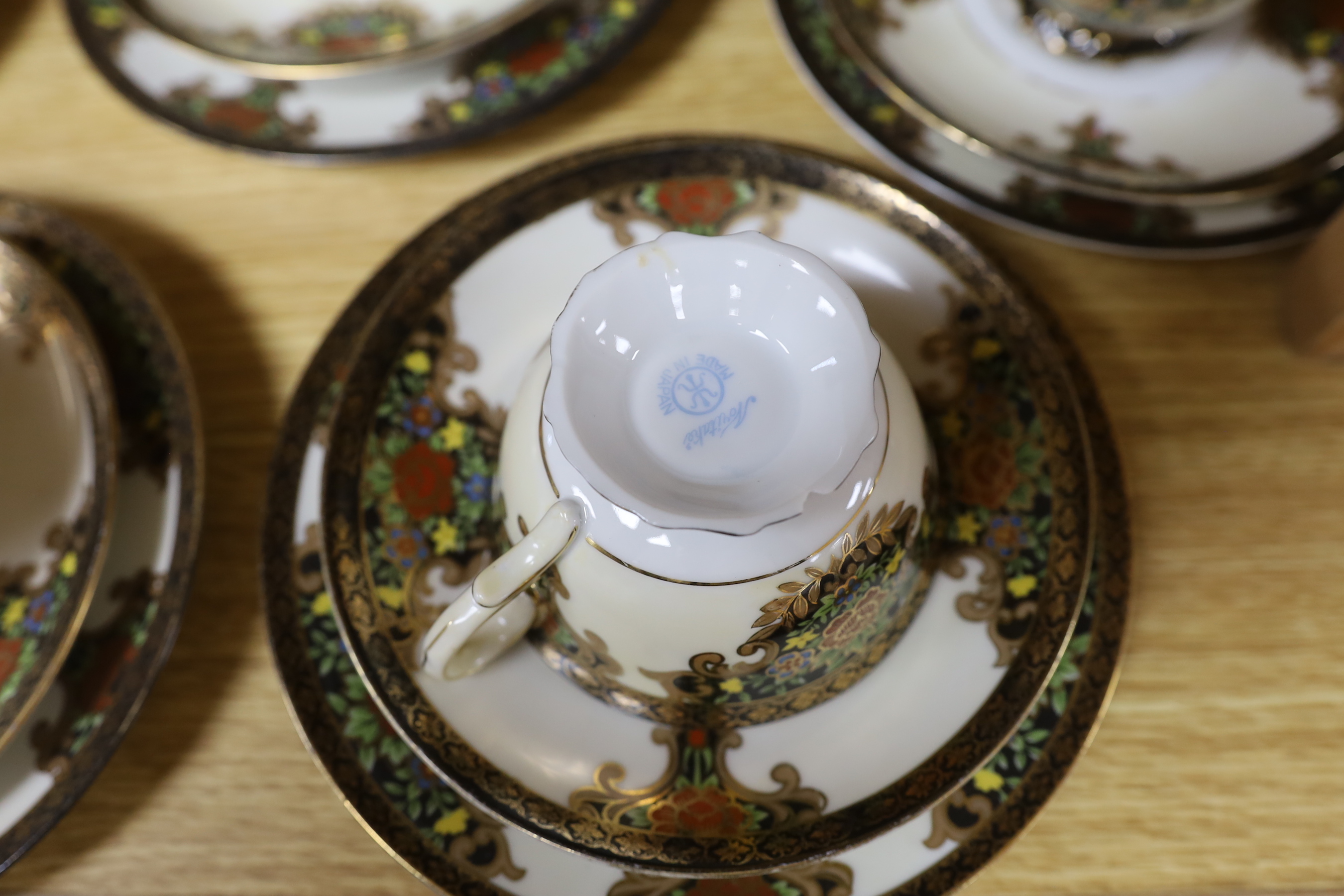A Japanese Noritake floral and gilt tea set, comprising a sugar bowl, a milk jug, nine cups, plus saucers and tea plates